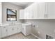 Bright laundry room featuring white cabinetry, quartz countertops, and patterned tile flooring at 1904 Illinois St, Orlando, FL 32803