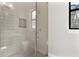 Modern tiled shower with glass enclosure, shower niche, and bright natural light at 1904 Illinois St, Orlando, FL 32803