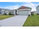 One-story house with green exterior, red roof accents, and a two-car garage at 5166 Tana Ter, Saint Cloud, FL 34772