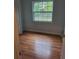 Bright bedroom featuring hardwood floors and a window offering a scenic outdoor view at 16 N Lancelot Ave, Orlando, FL 32835