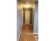 Hallway showcasing hardwood floors and a linen closet at the end of the hall at 16 N Lancelot Ave, Orlando, FL 32835
