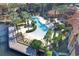 Stunning aerial view featuring community pool, palm trees, dock, and lush landscaping at 6107 Metrowest Blvd # 104, Orlando, FL 32835