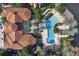 Aerial view displays community pool, palm trees, red umbrellas, and a clubhouse at 6107 Metrowest Blvd # 104, Orlando, FL 32835