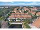 Aerial view of a condo community featuring meticulously landscaped grounds, red tile roofs, and a tranquil pond at 6107 Metrowest Blvd # 104, Orlando, FL 32835