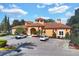 Charming clubhouse with beautiful landscaping, tile roof, and ample parking under a blue sky at 6107 Metrowest Blvd # 104, Orlando, FL 32835