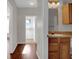 Hallway with wood floors leading to a laundry room and a bathroom with wood vanity at 6107 Metrowest Blvd # 104, Orlando, FL 32835