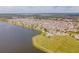 Wide aerial shot displays a community by a large lake with a pool, playground, and green space for outdoor enjoyment at 1511 Alligator St, St Cloud, FL 34771