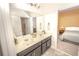 Elegant bathroom featuring a double sink vanity, decorative accessories, and a view into the bedroom at 1511 Alligator St, St Cloud, FL 34771
