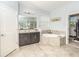 Bright bathroom featuring a soaking tub, walk-in closet, and a vanity with modern fixtures at 1511 Alligator St, St Cloud, FL 34771