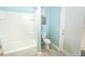 Clean bathroom featuring a tub, toilet, and glass-door shower, illuminated by natural light from a window at 1511 Alligator St, St Cloud, FL 34771