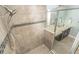 Walk-in shower featuring neutral tile, accent stripe, and modern fixtures, plus a view of a spacious vanity at 1511 Alligator St, St Cloud, FL 34771