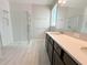 Modern bathroom with a glass-enclosed shower, double vanity with quartz countertop, and neutral flooring at 5286 Teirgarten St, Saint Cloud, FL 34771