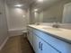 A full bathroom featuring double sinks, a quartz countertop, a large mirror, and a tiled tub-shower combo at 5304 Teirgarten St, Saint Cloud, FL 34771