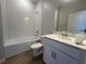 Neat bathroom featuring a single sink vanity, white cabinets, and a tiled tub and shower combination at 5304 Teirgarten St, Saint Cloud, FL 34771