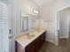 Bathroom featuring double sinks, wood cabinets, tile floor and an exterior door at 1147 Degraw Dr, Apopka, FL 32712