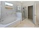 Bright bathroom featuring a soaking tub, glass shower, marble tile and a window at 1147 Degraw Dr, Apopka, FL 32712
