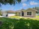 Charming single-story home with a well-manicured lawn, mature landscaping and a two car garage at 1147 Degraw Dr, Apopka, FL 32712