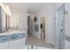 Bright bathroom featuring tiled walls, shower, and double vanity with a view down the hallway at 19808 Seaview St, Orlando, FL 32833