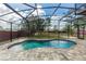 A screened-in pool area features a kidney-shaped pool, brick pavers, and a view of the backyard at 19808 Seaview St, Orlando, FL 32833