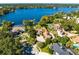 Aerial view of an upscale home on a lakefront property with lush landscaping and pool at 4024 W Danby Ct, Winter Springs, FL 32708
