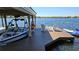 Modern boathouse with a covered seating area, a boat lift, and a beautiful view of the lake at 4024 W Danby Ct, Winter Springs, FL 32708