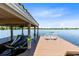 Covered boat dock features two Adirondack chairs on the deck for relaxing by the lake at 4024 W Danby Ct, Winter Springs, FL 32708