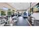 Well-equipped home gym with cardio machines and weights overlooking a tranquil lake setting at 4024 W Danby Ct, Winter Springs, FL 32708
