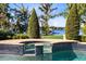 Beautiful pool and spa overlooking the lake, surrounded by lush landscaping and mature trees at 4024 W Danby Ct, Winter Springs, FL 32708