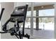 Close up of gym treadmill and view of the pool beyond the window at 308 Barebow Ln, Ormond Beach, FL 32174