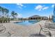 Inviting community pool with chairs and tables on a brick deck, ready for relaxation at 308 Barebow Ln, Ormond Beach, FL 32174