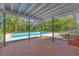 Covered back patio with brick and views of a sparkling pool at 5023 Golf Club Pkwy, Orlando, FL 32808