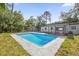 Backyard featuring a clear in-ground swimming pool surrounded by a concrete deck and lush greenery at 5023 Golf Club Pkwy, Orlando, FL 32808