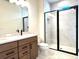 Modern bathroom with double vanity, quartz countertop, and tiled shower with glass door at 15106 Grove Lake Dr, Winter Garden, FL 34787