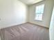 Carpeted bedroom with a window, perfect for relaxation and rest at 15106 Grove Lake Dr, Winter Garden, FL 34787