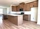Modern kitchen with stainless appliances, wood cabinets, island, and quartz countertops at 15106 Grove Lake Dr, Winter Garden, FL 34787