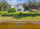 A backyard with lush green grass, a black metal fence and direct view of a lake in the back of the home at 1546 Water Elm Ct, Orlando, FL 32825
