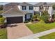 Charming two-story home with a well-manicured lawn and brick-paved driveway leading to a two-car garage at 1546 Water Elm Ct, Orlando, FL 32825