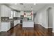 Modern kitchen with white cabinetry, a gray backsplash, stainless steel appliances, and dark hardwood flooring at 1546 Water Elm Ct, Orlando, FL 32825