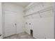 Functional laundry room featuring tile floors and ample shelving for organization at 1546 Water Elm Ct, Orlando, FL 32825