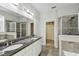 Main bathroom with granite counters, double sinks, a walk-in shower, and a large walk-in closet at 1546 Water Elm Ct, Orlando, FL 32825