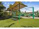 Community playground featuring slides, swings, and covered play areas on artificial turf at 1546 Water Elm Ct, Orlando, FL 32825
