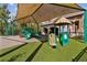 Community playground shaded by a canopy, featuring a variety of colorful play structures at 1546 Water Elm Ct, Orlando, FL 32825