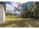 Lush backyard featuring well-maintained green grass and mature trees, providing a private and serene outdoor space at 8908 Sw 133Rd Ln, Ocala, FL 34473