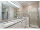 Bathroom featuring double sinks with granite countertops and a glass-enclosed shower at 8908 Sw 133Rd Ln, Ocala, FL 34473