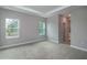 Spacious bedroom featuring plush carpeting, a tray ceiling and natural light from two windows at 8908 Sw 133Rd Ln, Ocala, FL 34473