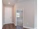 Bright entryway with wood-look flooring, white door, and an open view to a carpeted room with a large window at 8908 Sw 133Rd Ln, Ocala, FL 34473