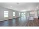 Spacious living room with recessed lighting and gray wood-look flooring leading to the kitchen at 8908 Sw 133Rd Ln, Ocala, FL 34473