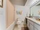 Well-lit bathroom featuring wood-style floors, white cabinets, a granite countertop and decorative peach-colored shower curtain at 2911 Sunset Vista Ct, Kissimmee, FL 34747