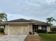 Inviting one-story home featuring a two-car garage, lush lawn, and screened entryway for added curb appeal at 2911 Sunset Vista Ct, Kissimmee, FL 34747