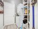 Efficient laundry area with stacked washer/dryer and shelving for organized storage in a well-lit space at 2911 Sunset Vista Ct, Kissimmee, FL 34747